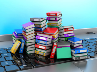Many colorful folders stacked in a row on a laptop. Ring binders