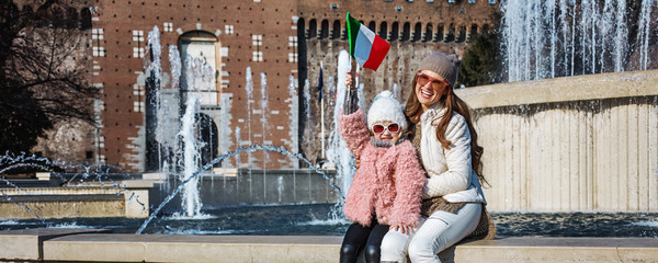 mother and child tourists near Sforza Castle rising flag