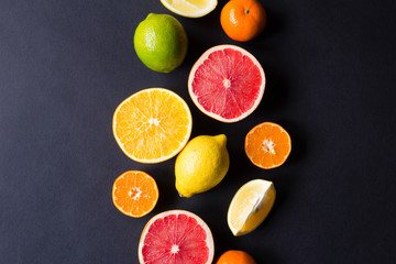 various types of citrus fruit on a dark background