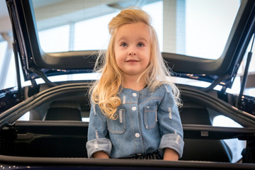 Small girl in car exhibition room