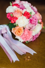 Wedding rings on a background of bridal bouquet