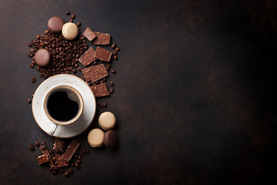 Coffee cup, chocolate and macaroons on old kitchen table