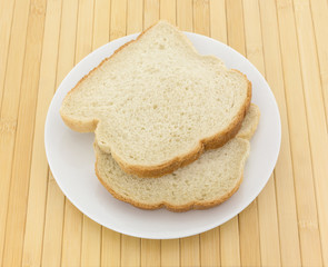 English muffin toasting bread slices on a white plate atop a wood place mat.