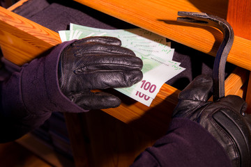 Geldscheine werden aus einer aufgebrochenen Möbelschublade gestohlen