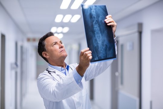 Male doctor examining x-ray in corridor