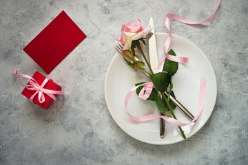 Valentines day table setting. Romantic food. Plate silverware present flower.