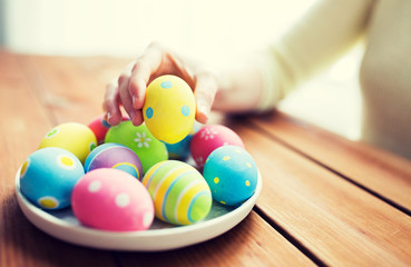Fototapeta na wymiar close up of woman hands with colored easter eggs