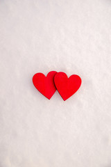 Two red hearts lie on the snow 