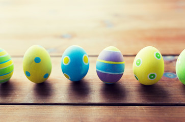 close up of colored easter eggs on wooden surface