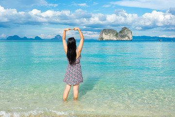 Woman in sea with love sign