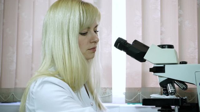 Research laboratory. Laboratory worker conducting a microscopic examination of blood. HD