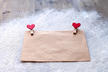The envelope of Kraft paper with two red clothespins in the shape of hearts, Valentine's day,...