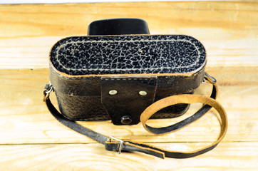 Old soviet rangefinder camera in leather case ona wooden table