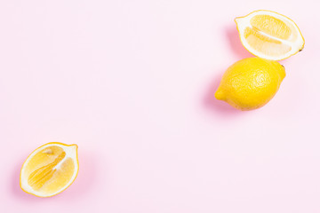 Whole and sliced lemon on pink background
