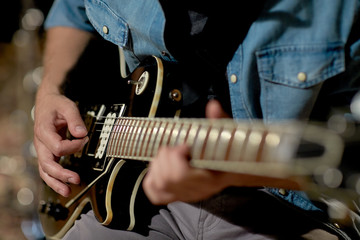 close up of man playing guitar at studio rehearsal