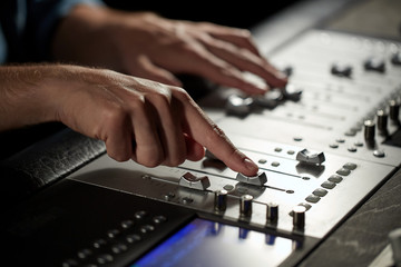 hands on mixing console in music recording studio