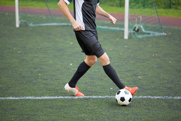 soccer player playing with ball on football field