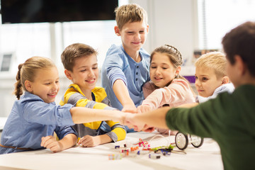 happy children making fist bump at robotics school