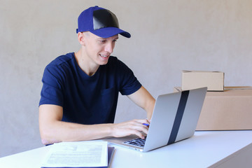 Courier Sitting at Desk, Typing on Computer in Post Office.