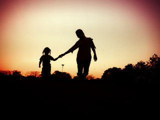 Fototapeta na wymiar silhouette of mother and little daughter play at sunset