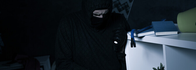 Burglar wearing a mask during robbery