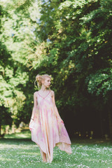 Fototapeta na wymiar Young beautiful blonde hair woman wearing pink dress standing in the forest - adventure, magic, dreamy concept