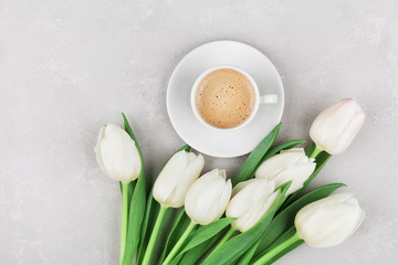 Obraz na płótnie Canvas Coffee mug with spring tulip flowers for good morning on gray stone table top view in flat lay style. Breakfast on Mothers or Womens day.