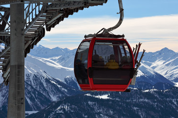 red cable car cabin with skiers in the skiing resort in Alps