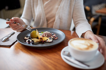 woman eating ice cream dessert with coffee at cafe