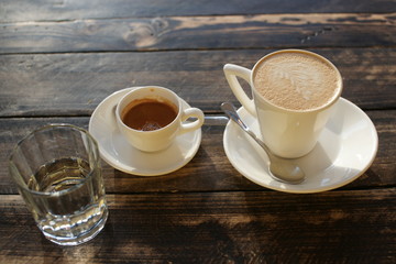 A cup of strong coffee and cappuccino on the table on a sunny day