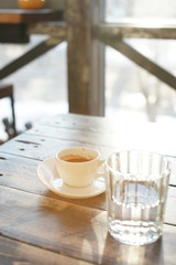 A cup of strong coffee on a table on a sunny day