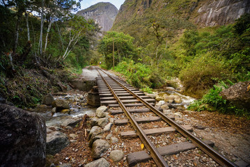 Railway track crossing jungle and Urubamba river, connecting Machu Picchu village to hydroelectric station, mostly used for tourism and cargo purpose.