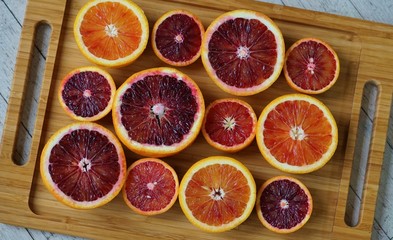 Tray of ruby red blood oranges cut in half 