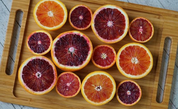 Tray of ruby red blood oranges cut in half 