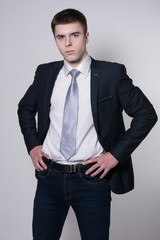 Portrait of serious young businessman hands on his belt