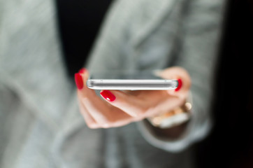 Women holding modern smartphone in hand. Horizontal view. Technology and business concept. 