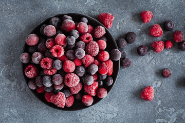 Frozen raspberry, blueberry, cranberry on grunge background. Frozen fruit. Top view, close up