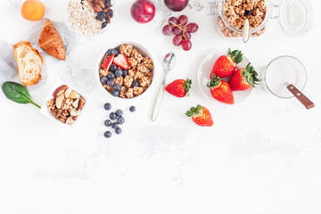 Healthy breakfast with muesli, fruits, berries, nuts on white background. Flat lay, top view