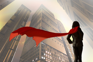3D Illustration of business woman dressed in a suit with a Cape superhero on the background of skyscrapers of the city © de Art
