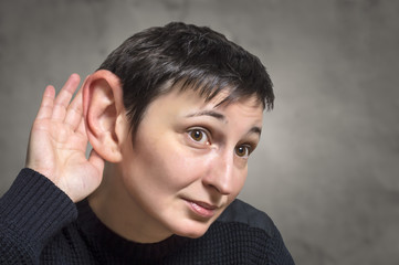Serious woman with one big ear listening attentively
