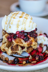 Belgium waffles served with yoghurt, berry compote, pecans, chocolate sauce and maple syrup