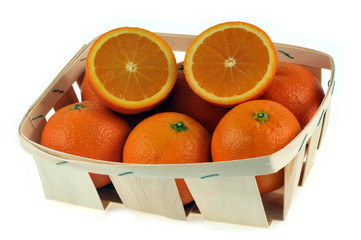 Cagette d'oranges avec l'une d'entre elles coupée en deux