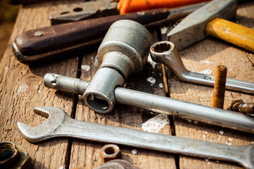 On weathered old wooden surface lie the , oily wrenches.