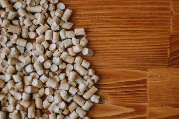 Biofuel - small wooden pellets over the wooden table.