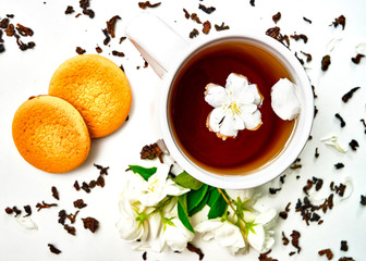 Teacup with dried and fresh Jasmine flowers and cookies
