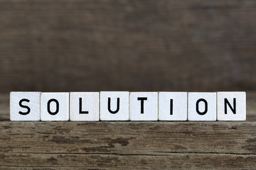 Solution, written in cubes on wooden background