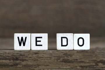 We do, written in cubes on wooden background