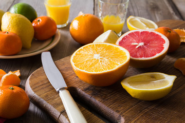 various types of citrus fruit on a wooden background