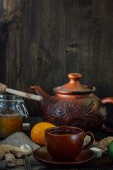Set of ceramic teapot and cup with ginger tea in it.