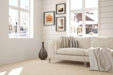 White interior design with sofa and winter landscape in window